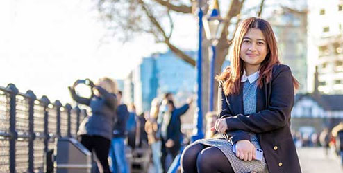 Students sitting on a bench on a city street