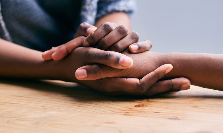 close-up shot of holding hands for comfort and emotional support