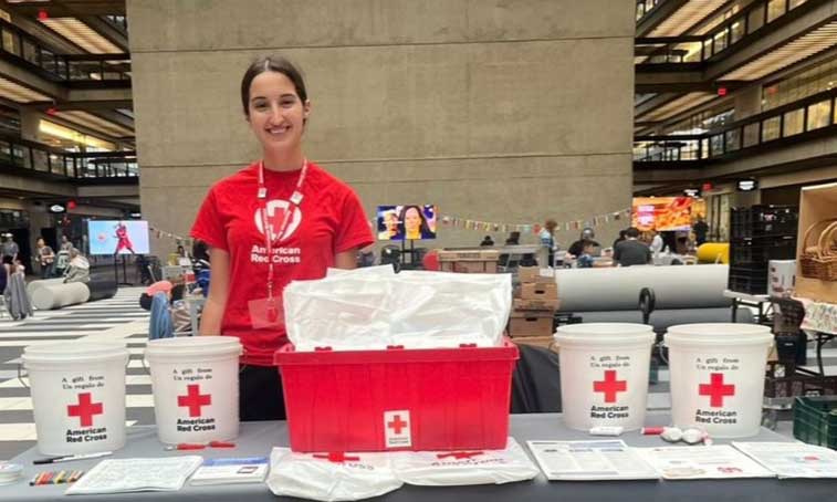 Leila Grebby standing at the American Red Cross stand 