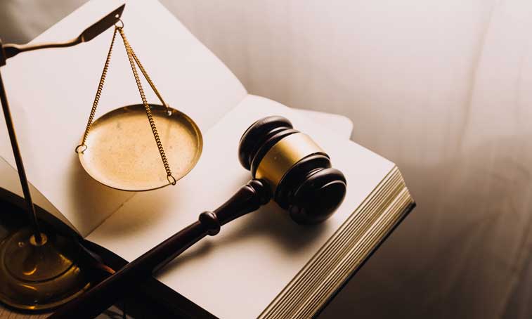 a Scale of Justice and a gavel on a book representing law