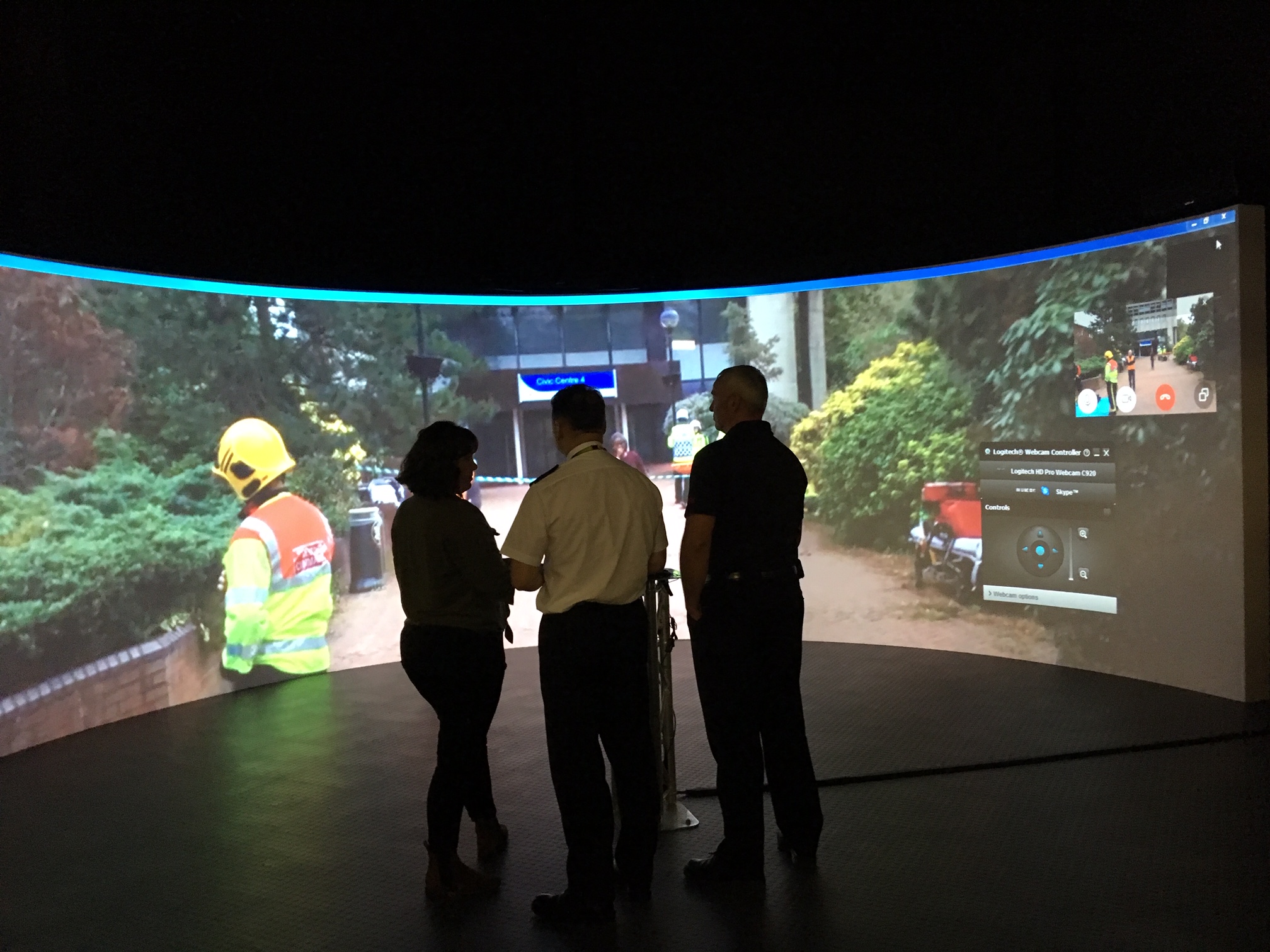 A large projection screen of firefighters working