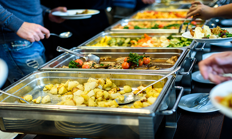 People helping themselves to food at a social eating space