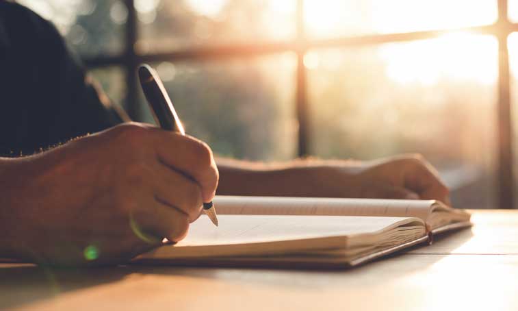 a creative writer making notes in the handbook