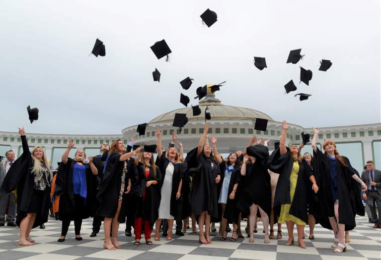 Students throwing mortarboards in air