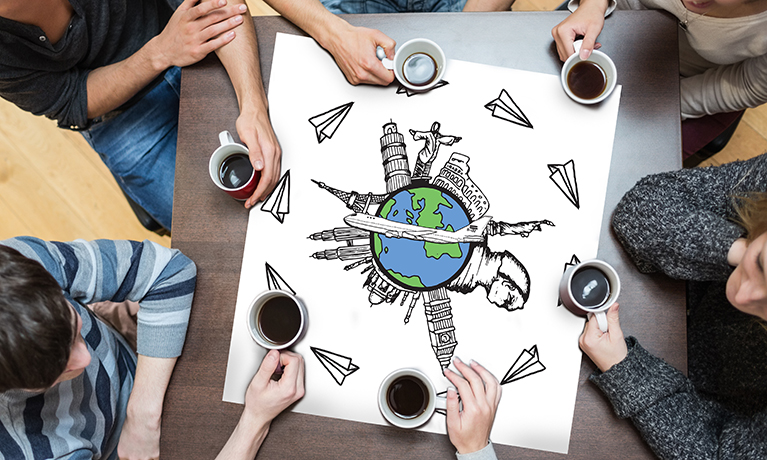 People sitting around table drinking coffee with page showing landmarks of the world with airplane doodle