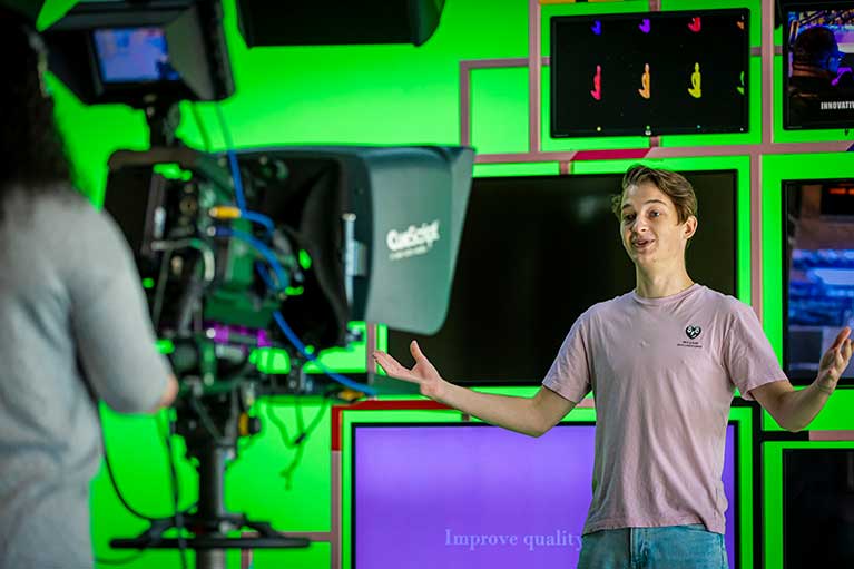 a student in front of a camera at Coventry University studio