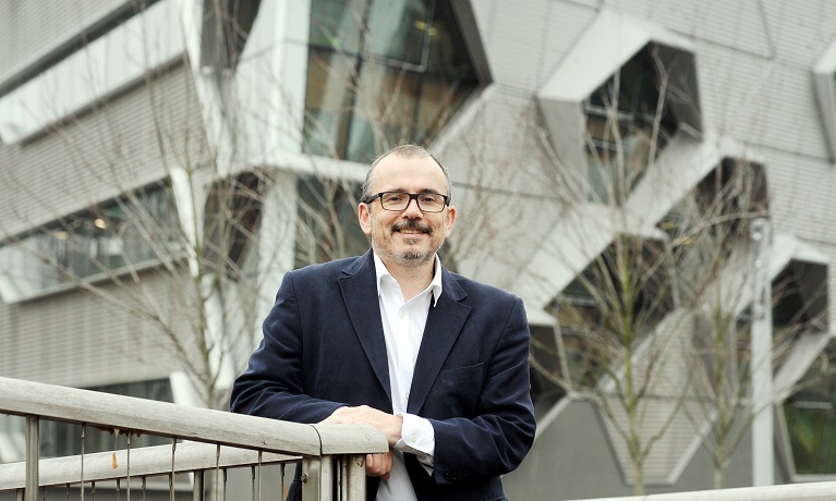 A man standing in front of a silver building
