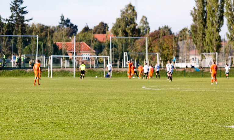 Shallow depth of field shot of group of male soccer players playing amateur soccer match