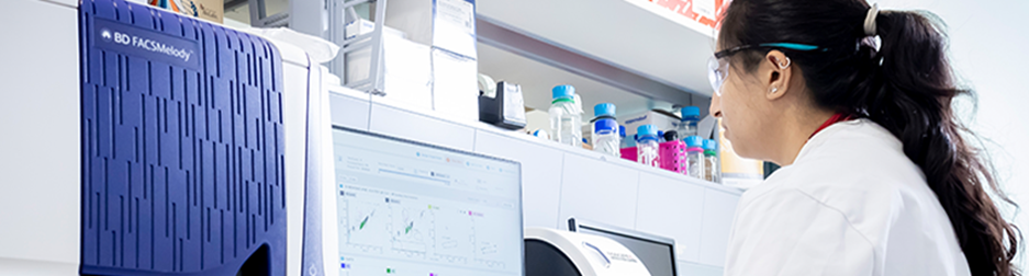 woman in a lab wearing a lab coat on a computer