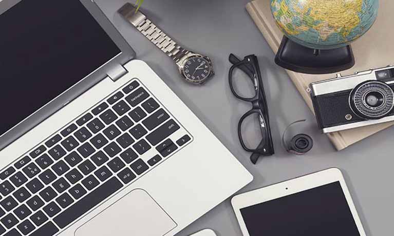 Laptop leyboard on desk with glasses and mobile phone