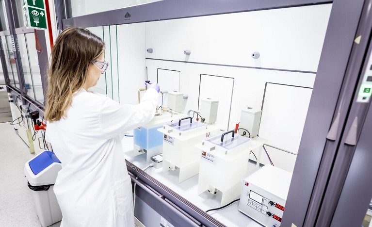 student in lab coat conducting an experiment in a labatory