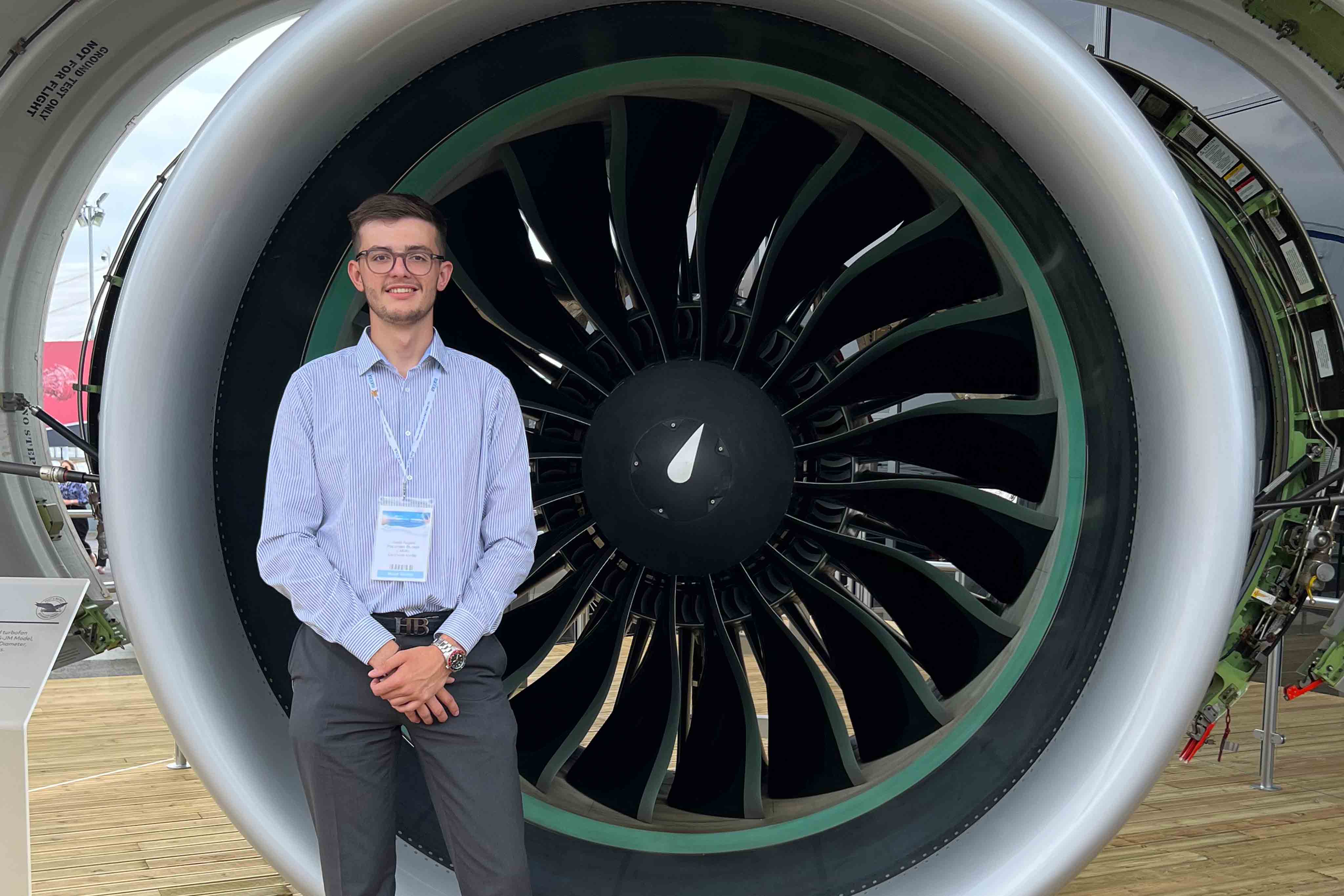 Jacob Rogers in front of a jet engine