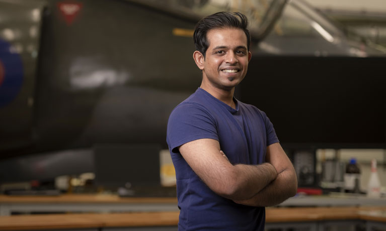 Student with folded arms smiling at the camera