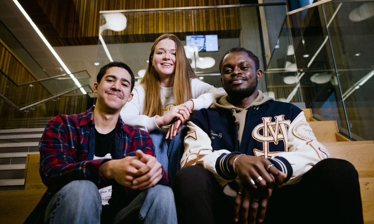 Group of students sat at a table smiling