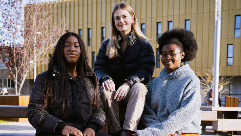 Four students sat on steps talking