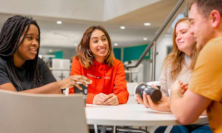 1 boy and 3 girls sitting around a table in canteen 