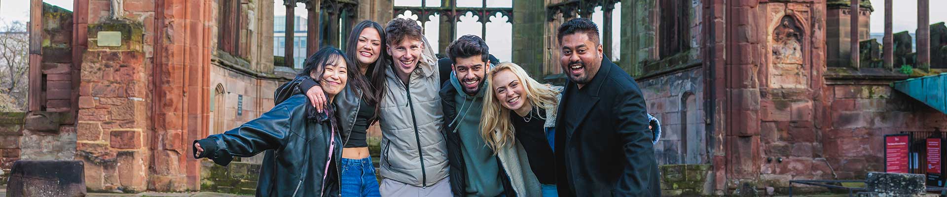Group of students stood together in the Coventry Cathedral ruins