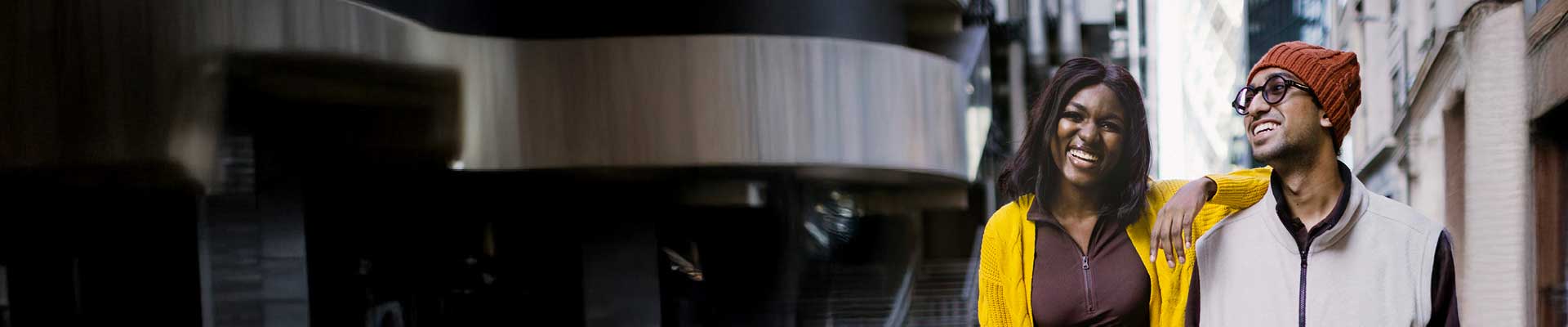 female and male student smiling standing on a street