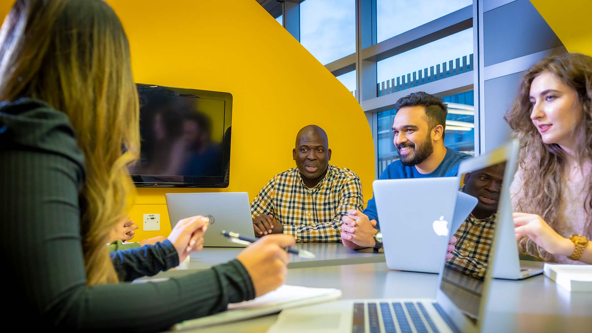 Four students in discussion across a table