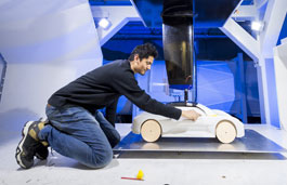 Student leaning over an automotive prototype model