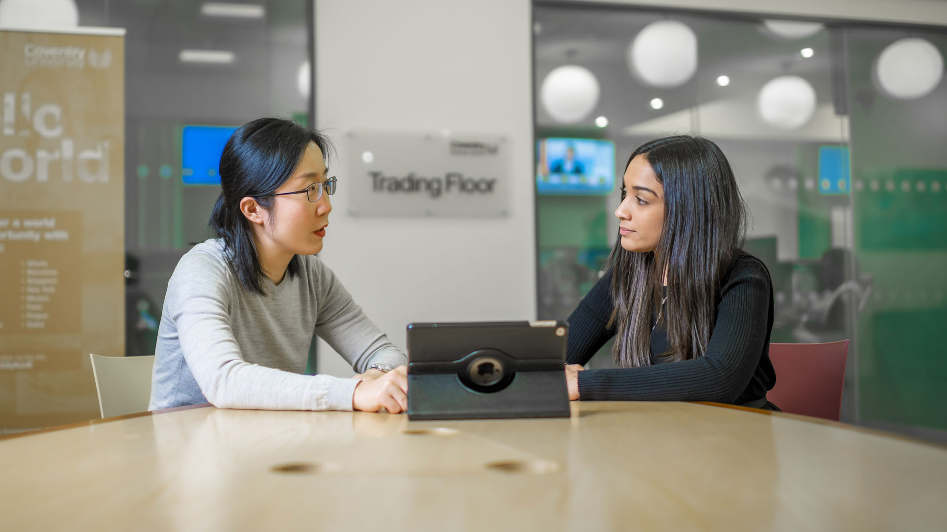 two females in a room looking at a tablet 