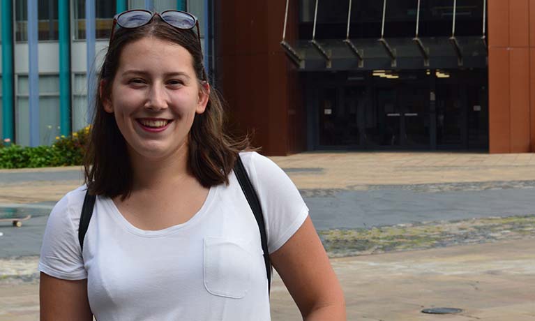 A close up portrait of Sabina in front of a Coventry University building