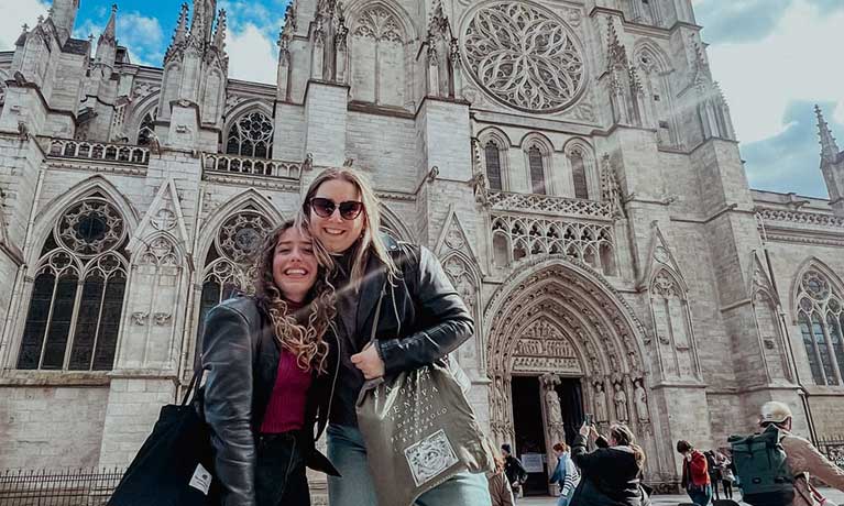 Sonia with a friend outside a cathedral in Bordeaux