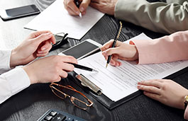 Close up of students hands discussing details on a clipboard.