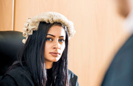 A student using the mock courtroom, wearing a court wig.