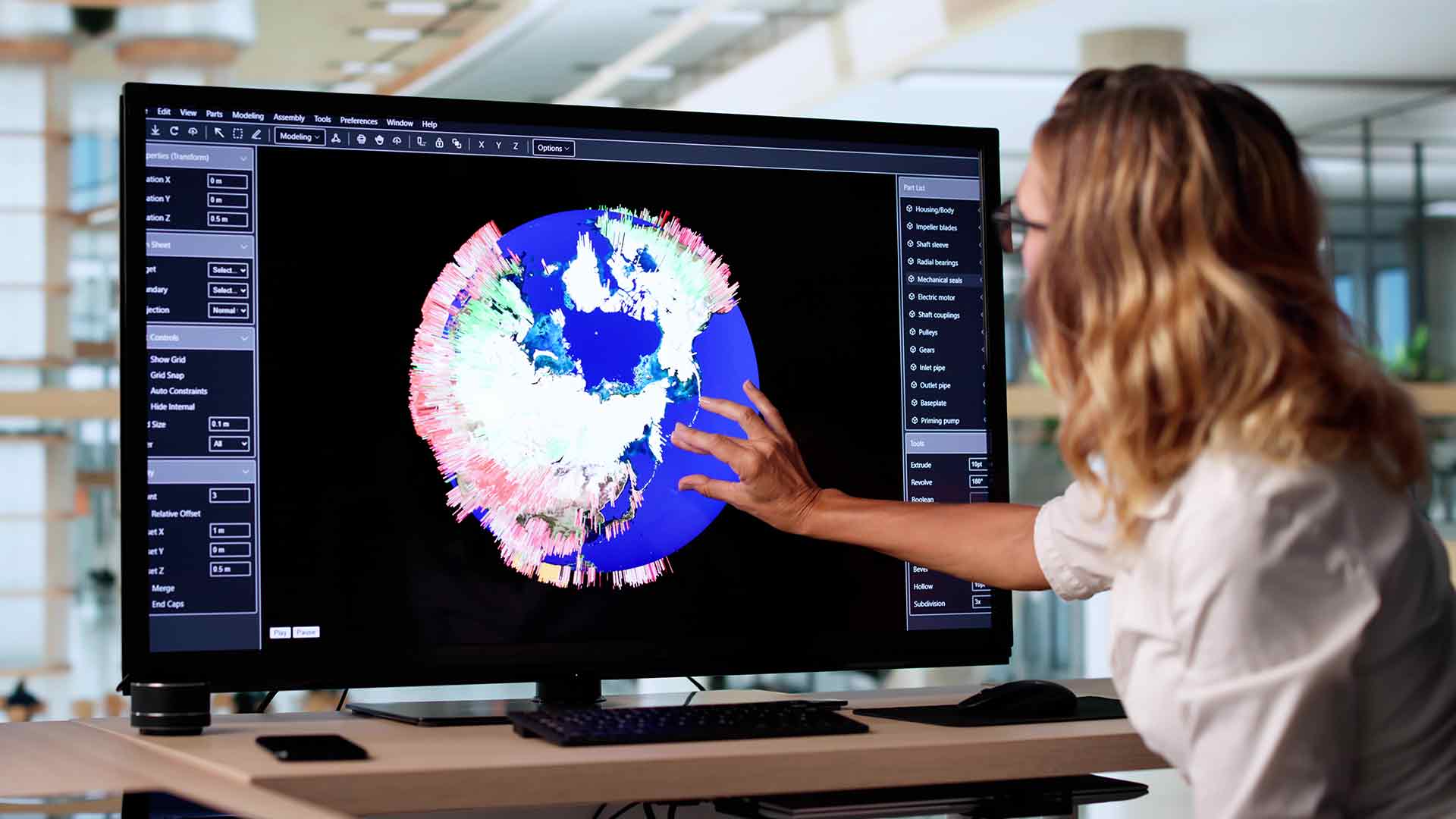 A woman pointing at a data graph on a computer screen