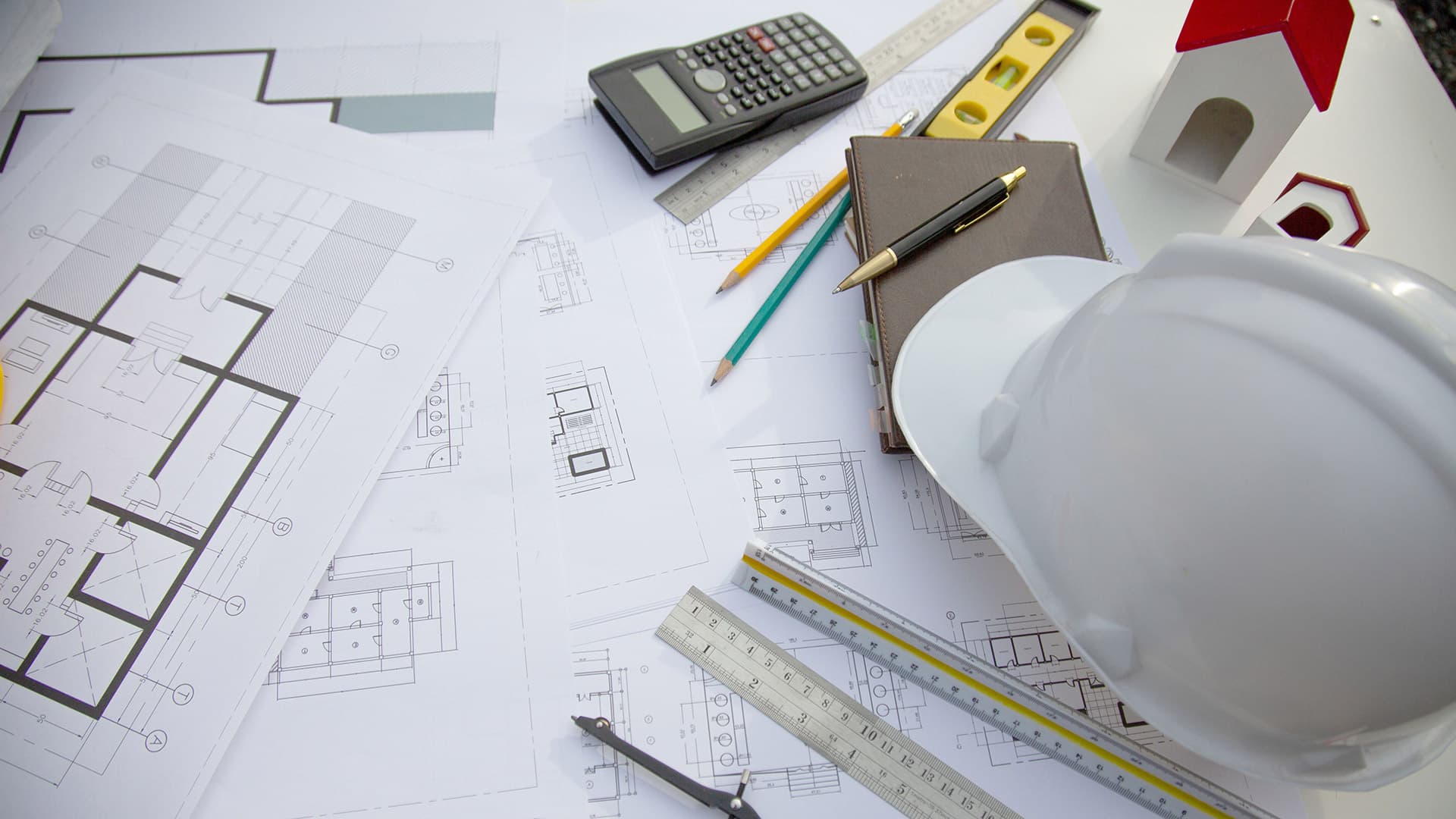 Architectural plan with stationery and hard hat on the side