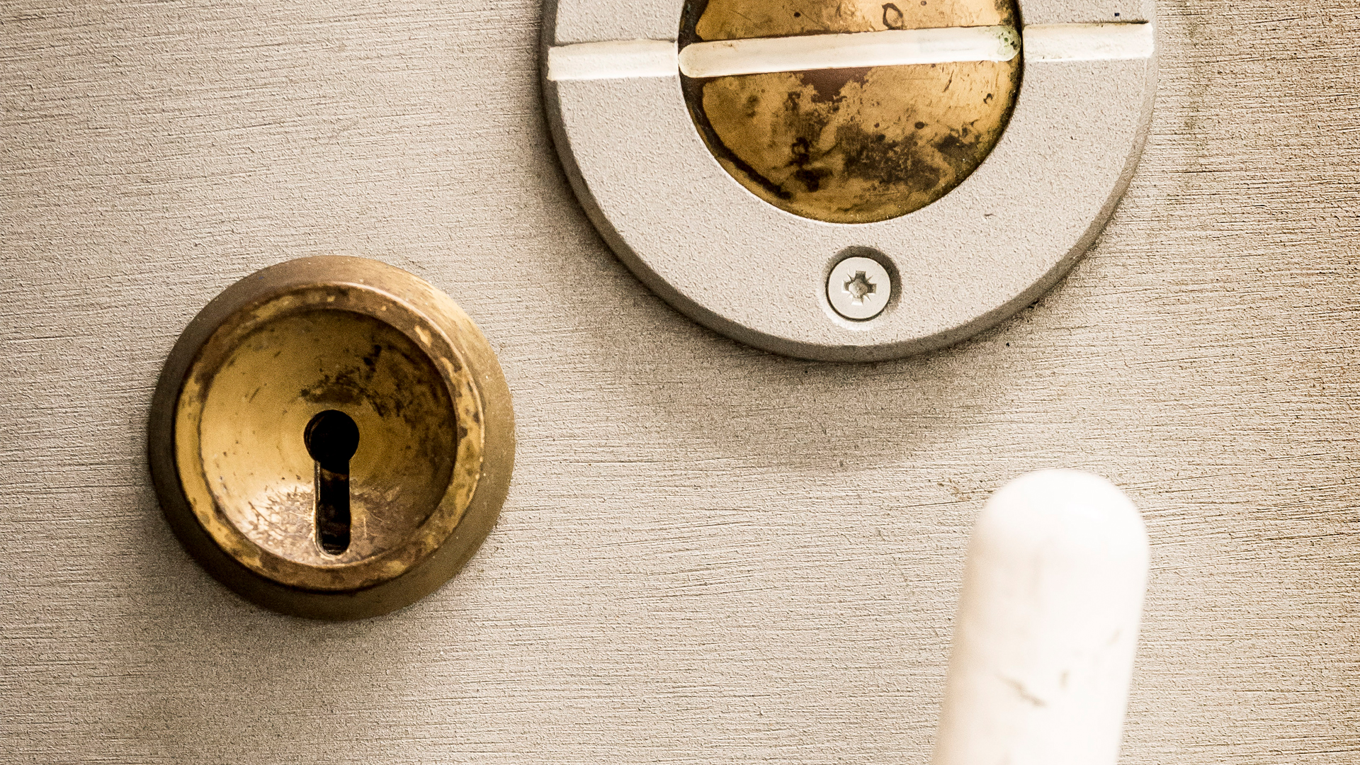 Close-up of a circular gold metal lock and a circular metal piece above