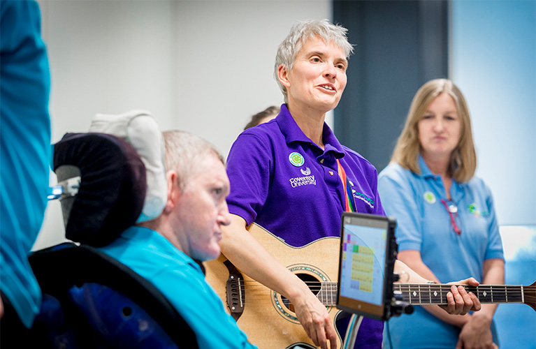 A close up of a woman playing guitar therapy