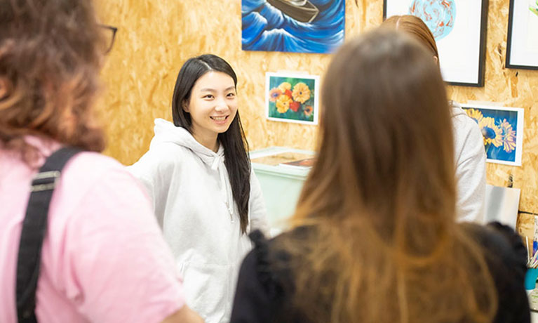 Group of students looking at a wall of art 