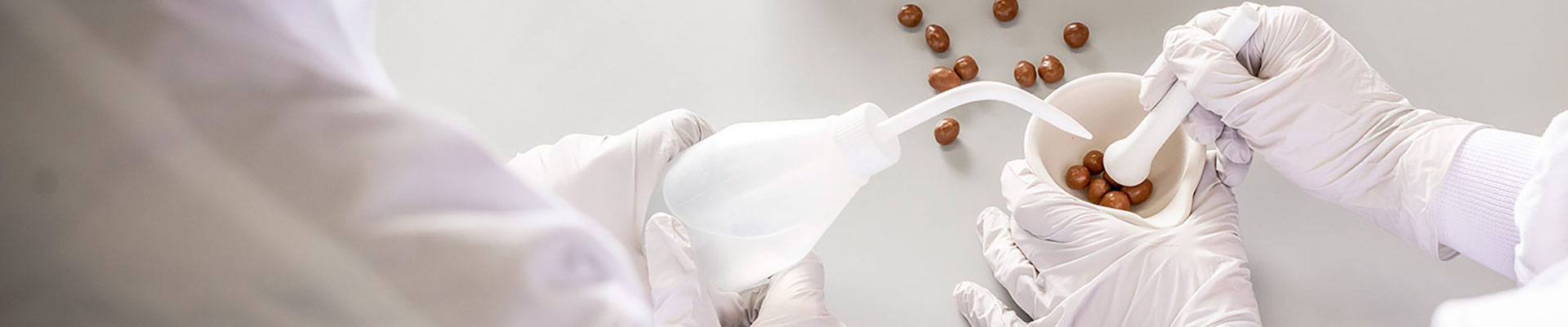 Two people working in a lab with a mortar and pestle