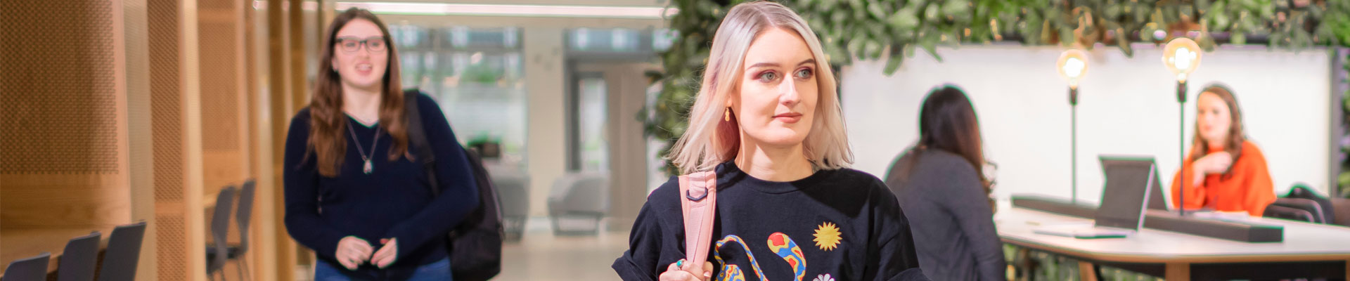 A student carrying a backpack, walking through the Beatrice Shilling building.