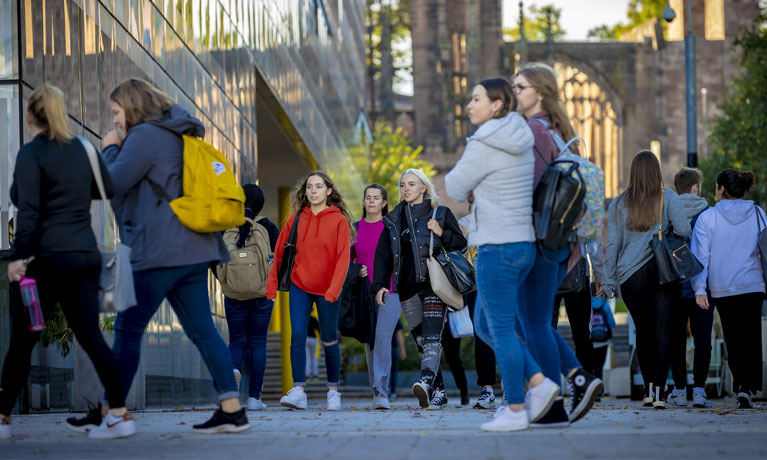 A group of students walking into a campus building