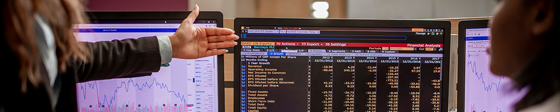 Two females looking at business data on screen.