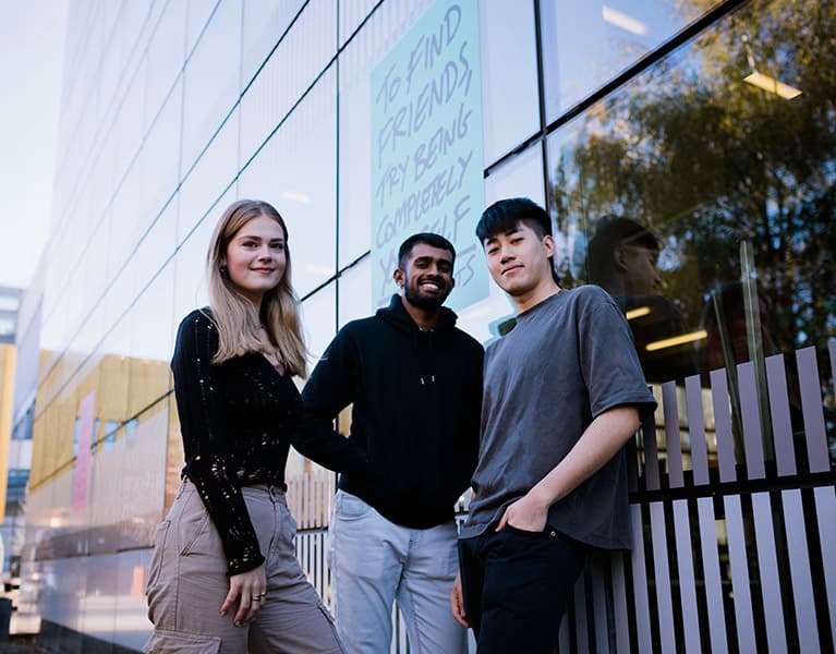 Students standing together outside of the student hub