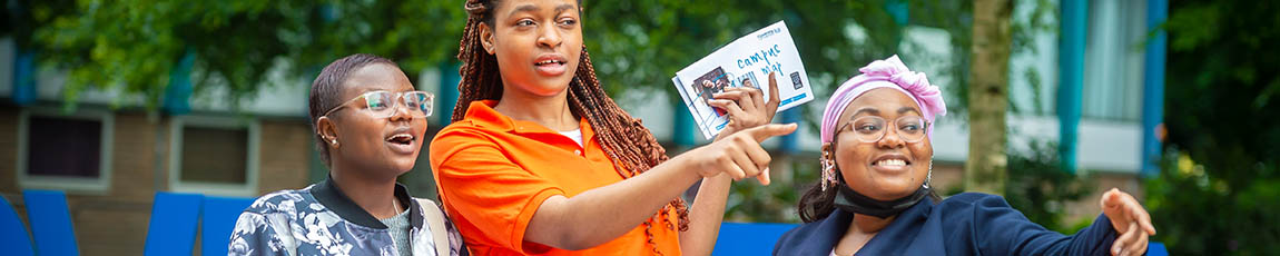 Two students receiving directions from a student ambassador.