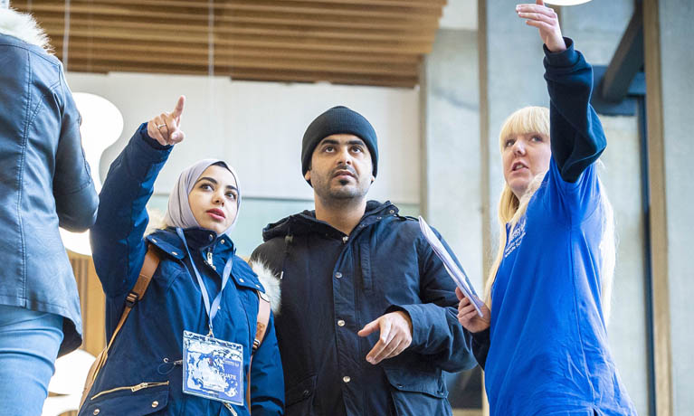 3 students looking up at a building 