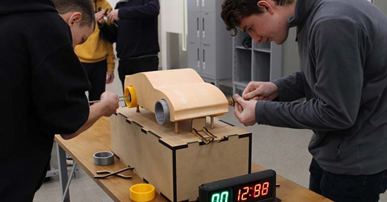 Motorsport Engineering BEng (Hons) students working on a model car