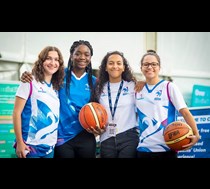 4 young females in sports clothes smiling looking at the camera 