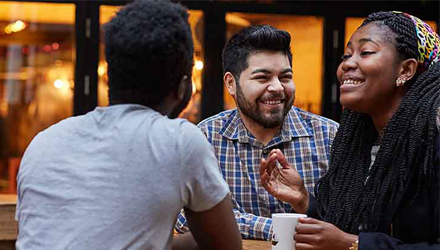 A group of students laughing inside a coffee shop.