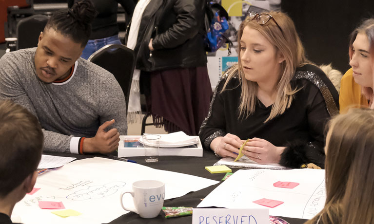 Students sat at table in discussion.