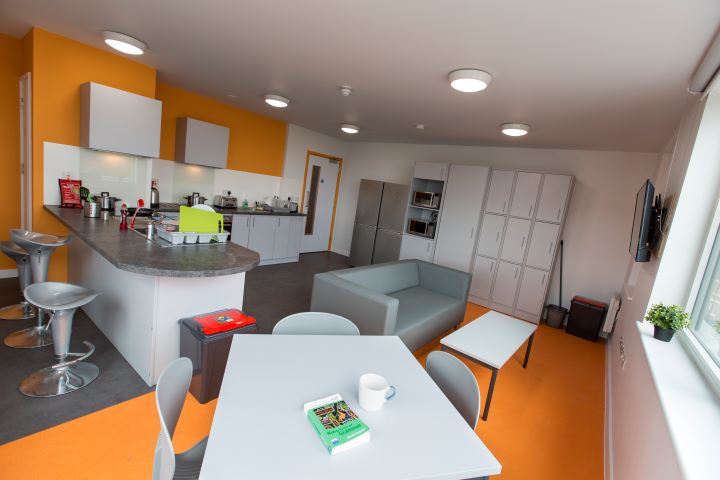 Shared kitchen space with various cupboards and dining table