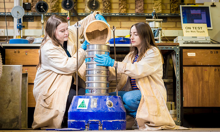 Students in lab coats in the Geotechnics Laboratory