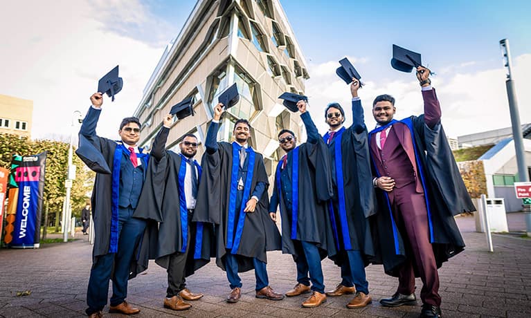 A group of graduates about to throw their caps in the air