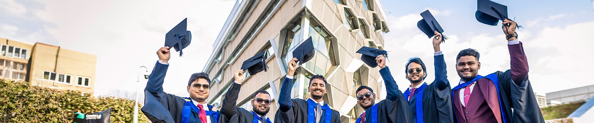 Group of students throwing their graduation caps up into the air