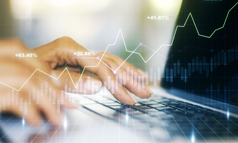 Abstract creative financial graph with hand typing on laptop on background, forex and investment concept. Multiexposure